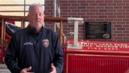 A person stands in front of an antique fire truck